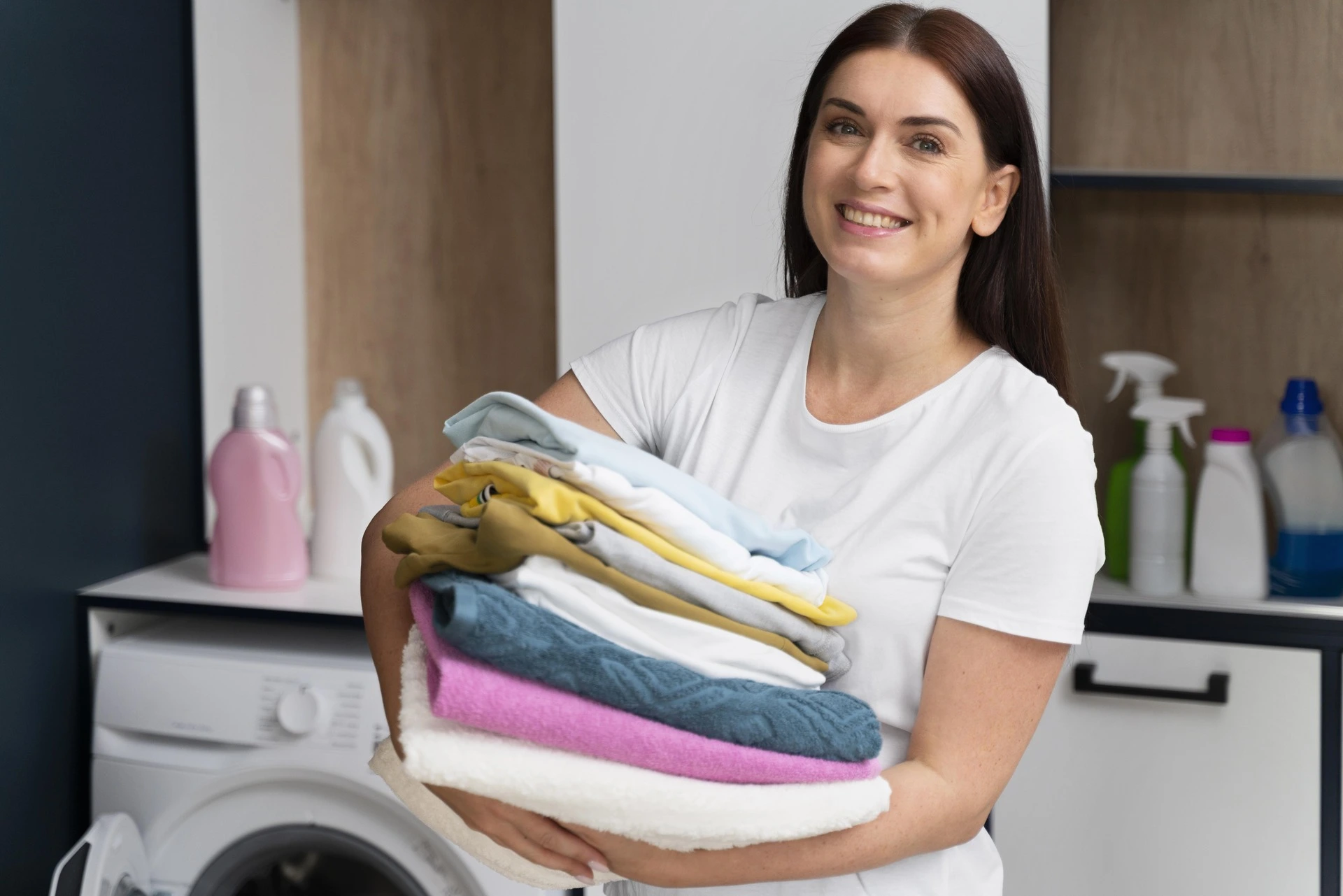 Woman holding clean clothes at Shree Dhobi Express